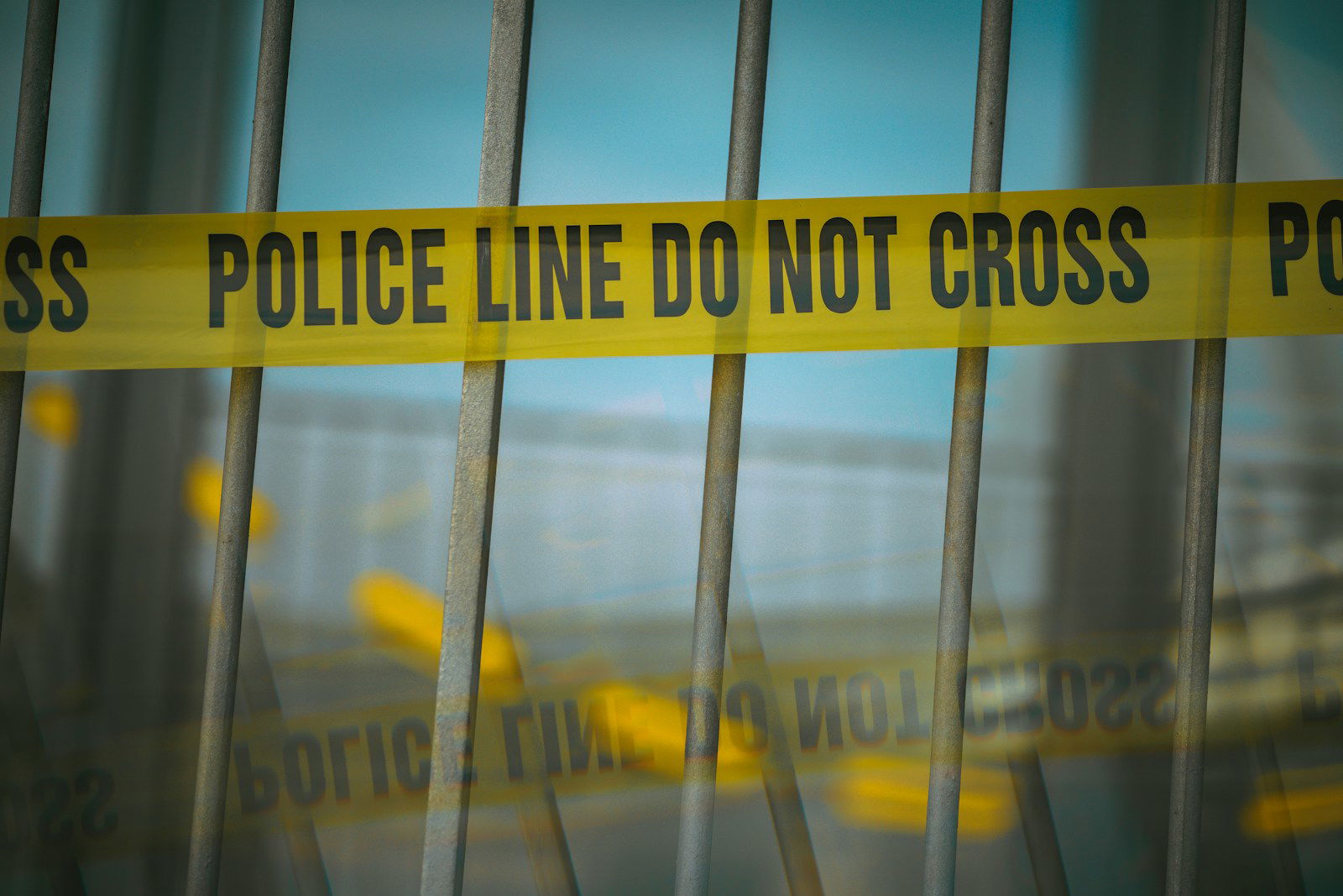 a close up of a yellow police line behind bars