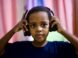 A young boy listening to headphones in a room