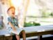 boy sitting on bench while holding a book