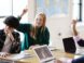 Teenage girl in school class, hand raised
