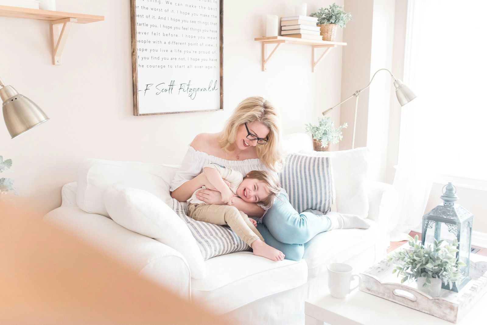 Photo by Paige Cody woman and baby sitting on white sofa