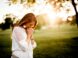 woman praying beside tree