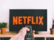 person holding remote pointing at TV