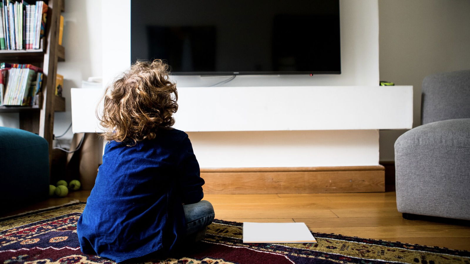 Rear view of a kid sitting and watching television