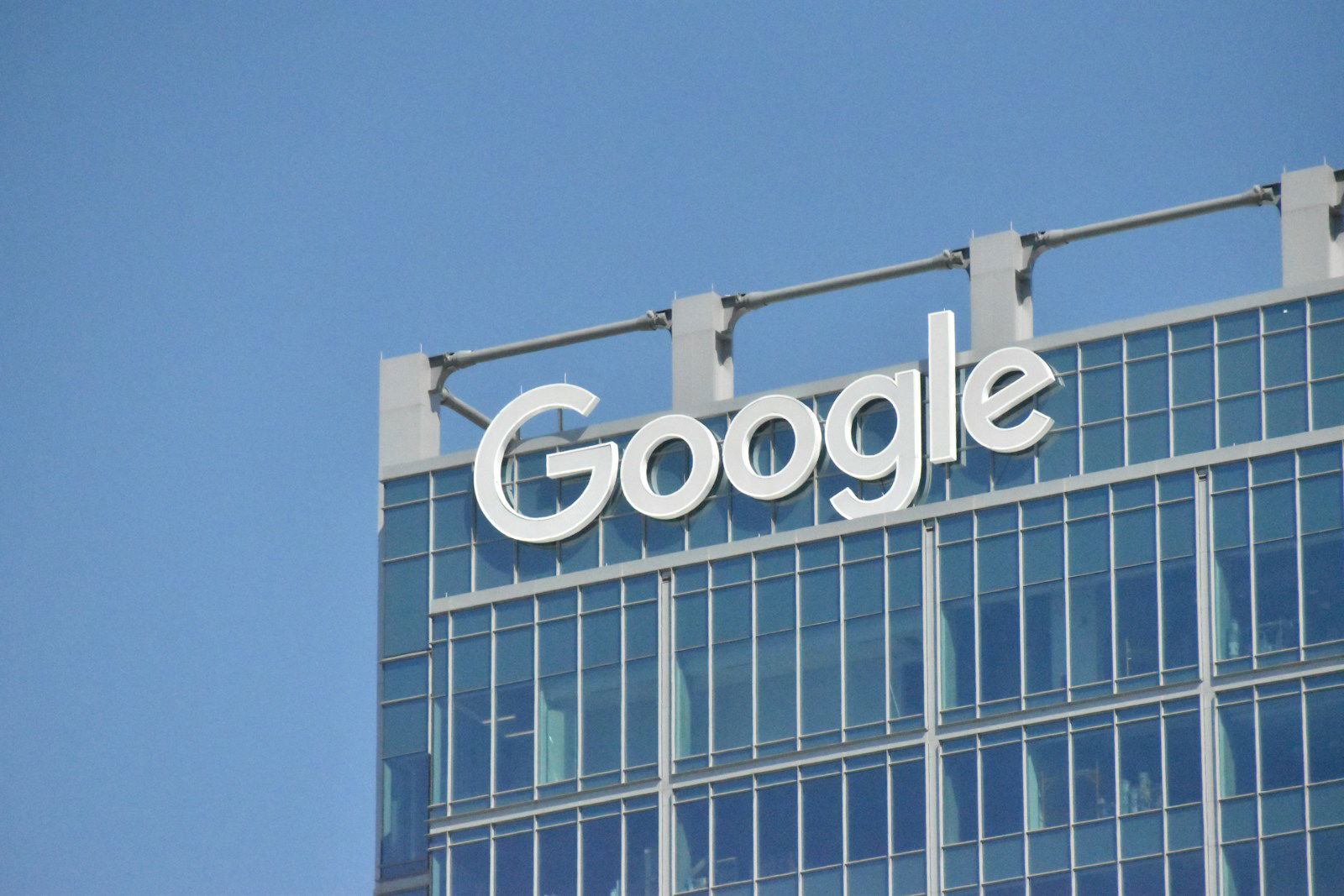 Photo by Simon Ray A tall building with the google logo on top of it