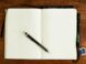 black and silver retractable pen on blank book