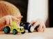 child playing with two assorted-color car plastic toys on brown wooden table