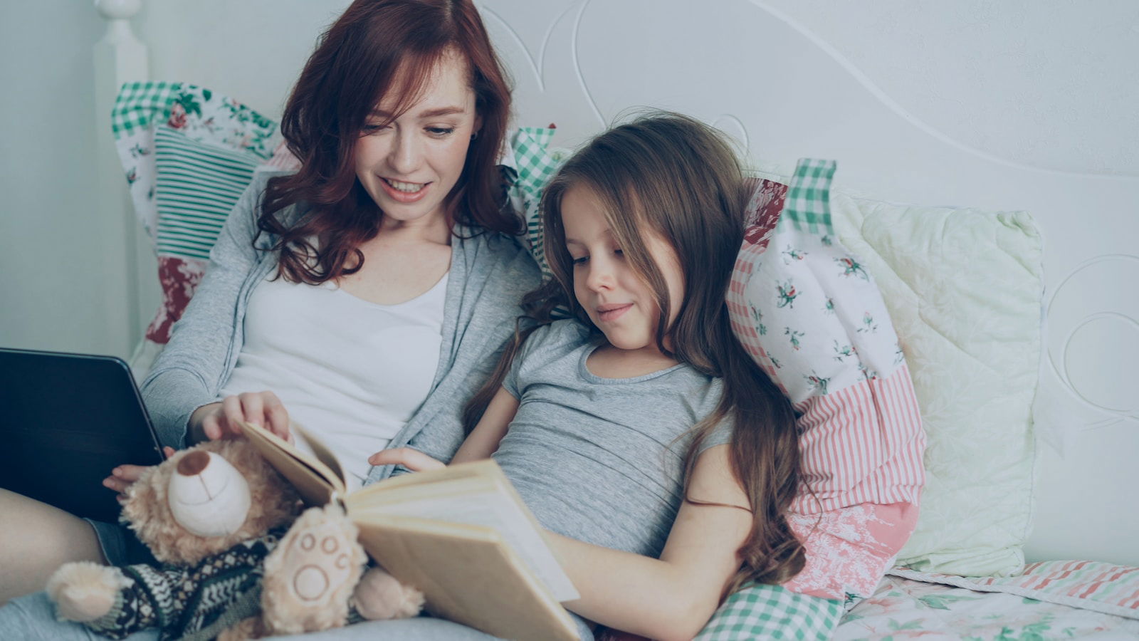 Mom and daughter read a book together.