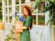 woman in green and white polka dot dress holding brown woven basket