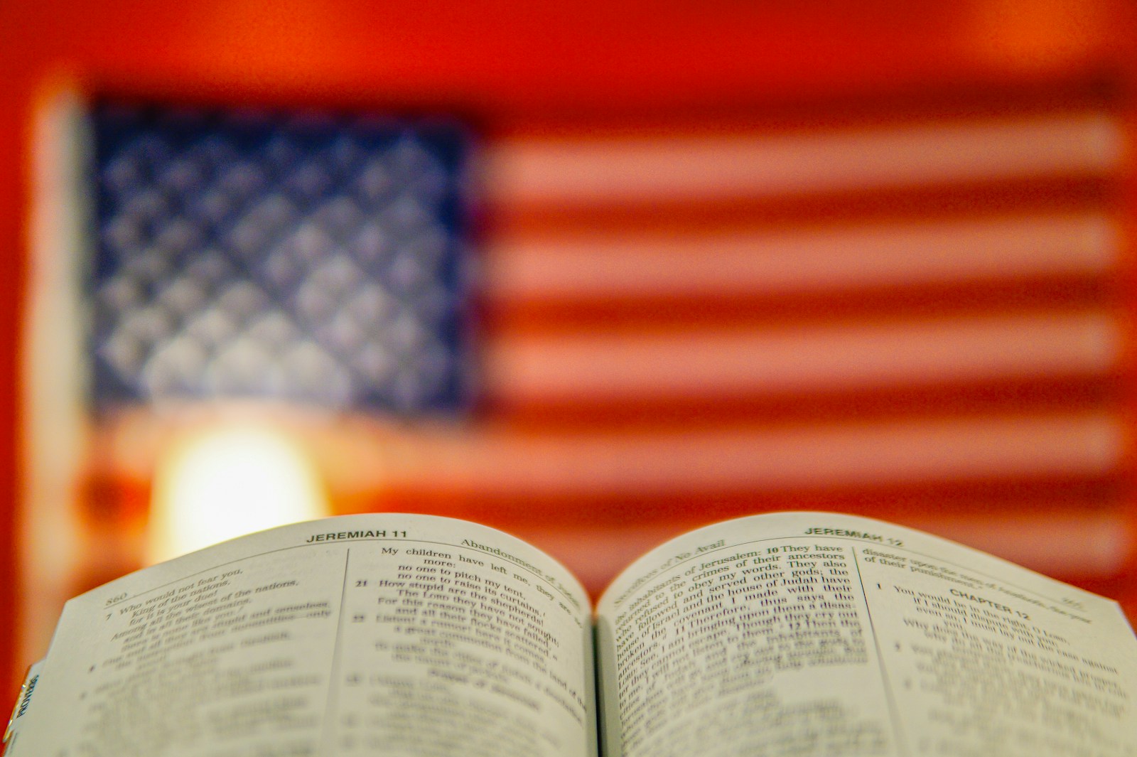 An open book with a blurred american flag background.