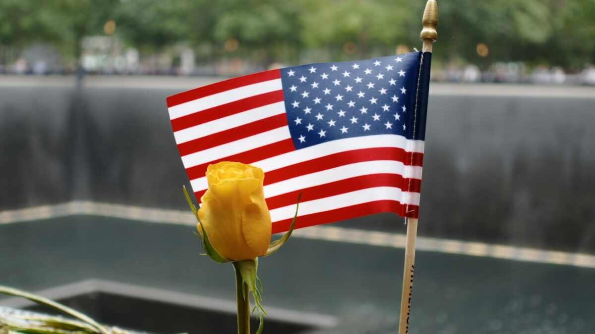 a flag and a flower on a memorial